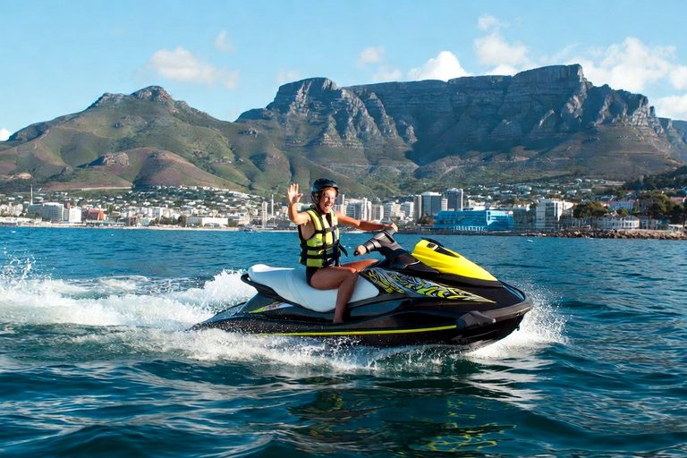 Rider waving from a jet ski on Table Bay with Table Mountain behind