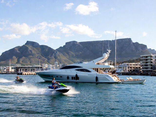Jet ski in front of a luxury yacht at the V&A Waterfront with Table Mountain behind